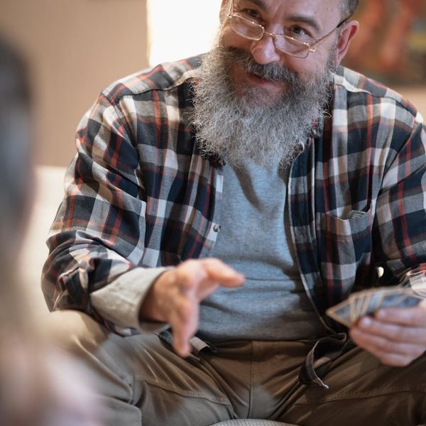 Smiling woman stretching gently on a yoga mat.